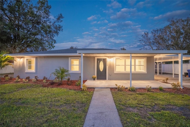 ranch-style home with a front yard and a carport