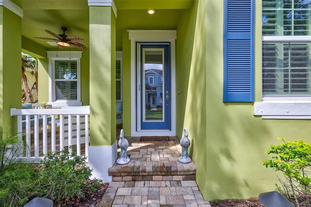 doorway to property featuring ceiling fan and a porch