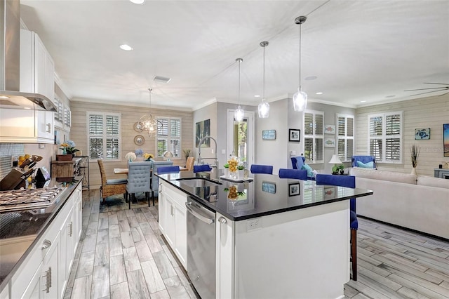 kitchen featuring dishwasher, sink, an island with sink, and white cabinets