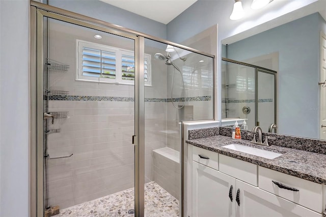 bathroom featuring vanity and a shower with door