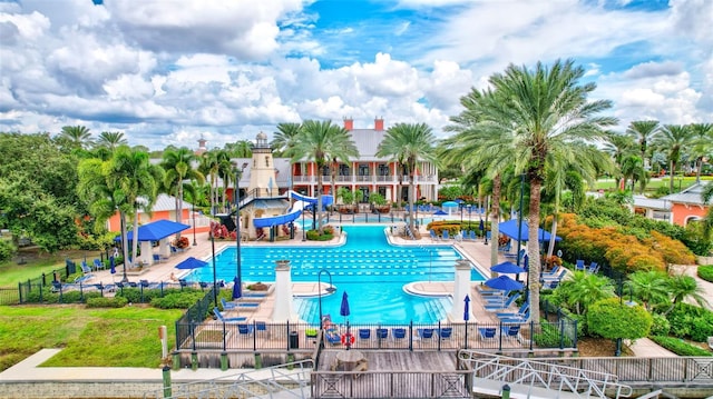 view of pool featuring a lawn, a patio, and a water slide