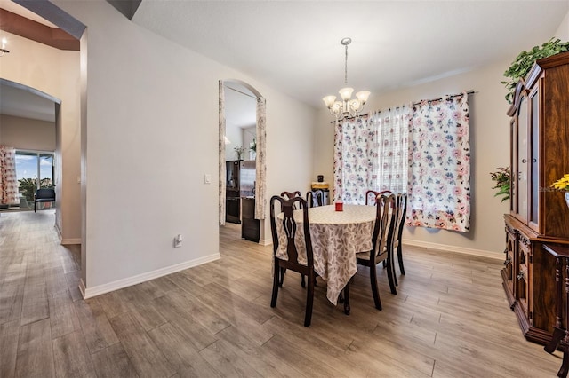 dining space featuring an inviting chandelier and light wood-type flooring