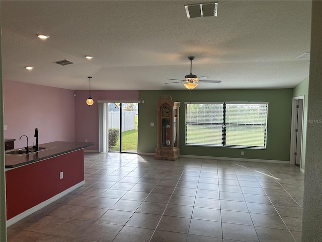 interior space featuring sink, ceiling fan, and a textured ceiling