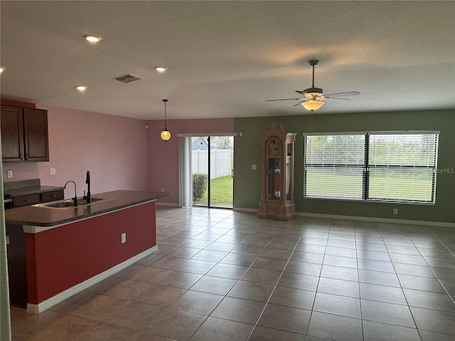 kitchen featuring plenty of natural light, light tile patterned floors, ceiling fan, and sink