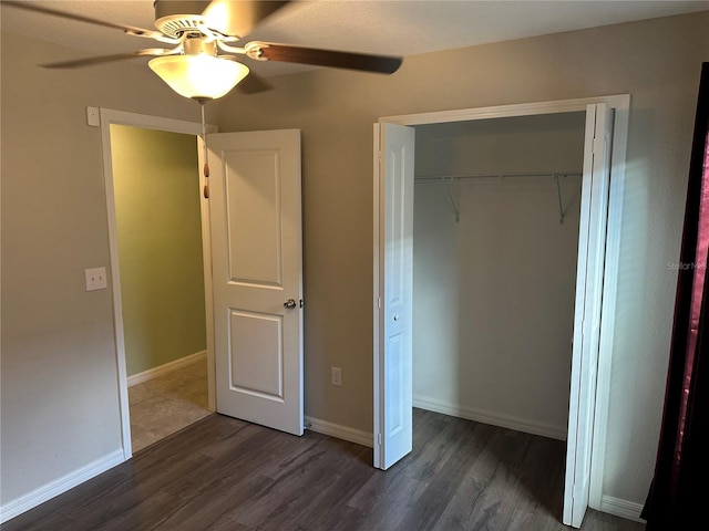 unfurnished bedroom with dark wood-type flooring, ceiling fan, and a closet