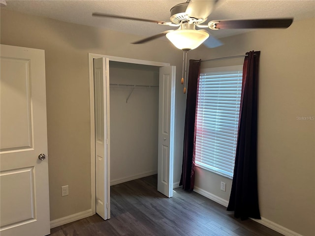 unfurnished bedroom featuring dark wood-type flooring, ceiling fan, a textured ceiling, and a closet