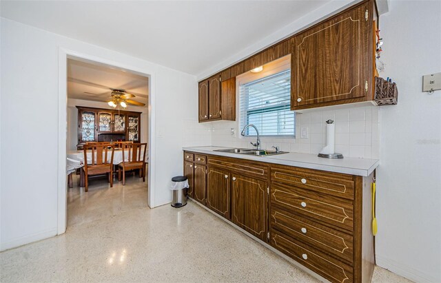 kitchen with backsplash, ceiling fan, and sink