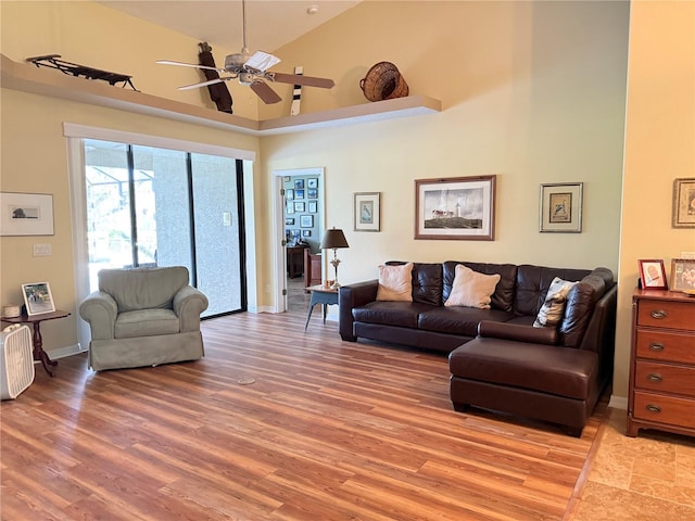 living room featuring ceiling fan, light wood-type flooring, and high vaulted ceiling