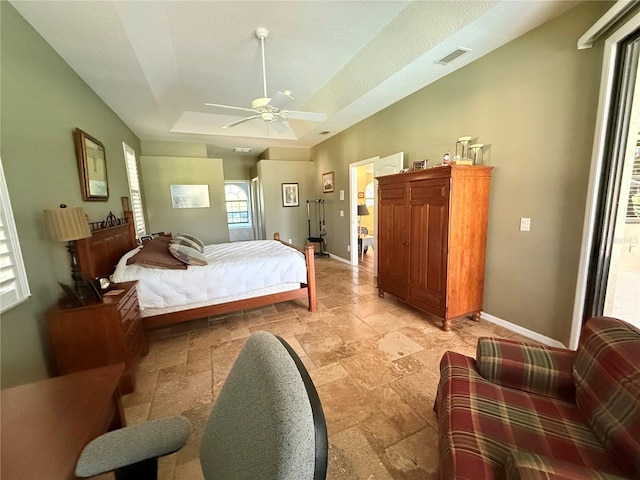 bedroom with ceiling fan, a textured ceiling, and a raised ceiling