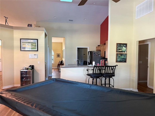 playroom featuring hardwood / wood-style flooring, billiards, sink, and high vaulted ceiling