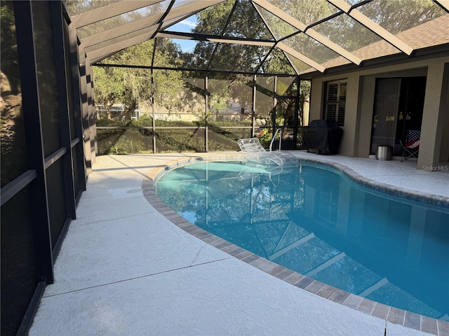 view of swimming pool featuring a patio, a lanai, and a grill