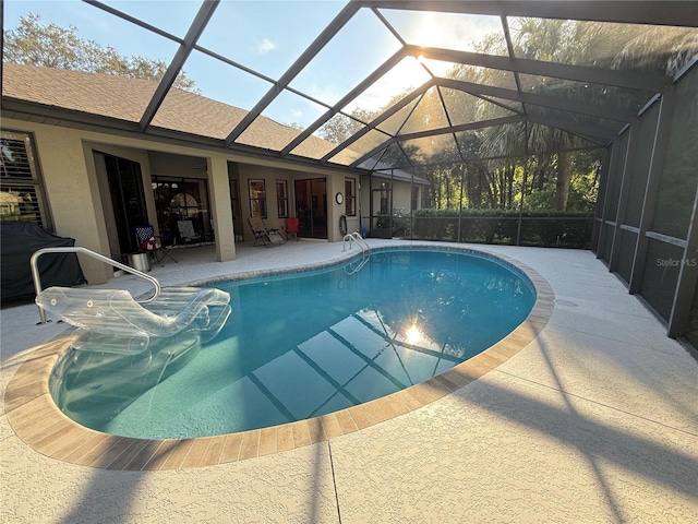 view of swimming pool featuring a lanai and a patio