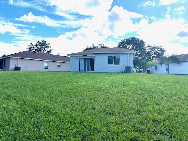 back of property with cooling unit and a yard