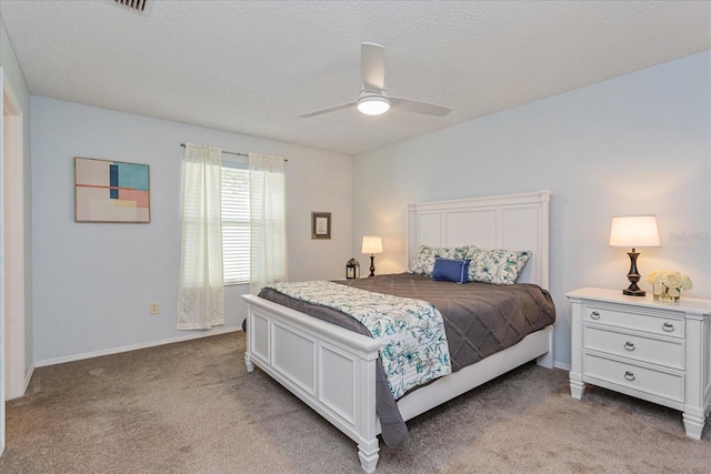 bedroom with light carpet, ceiling fan, and a textured ceiling