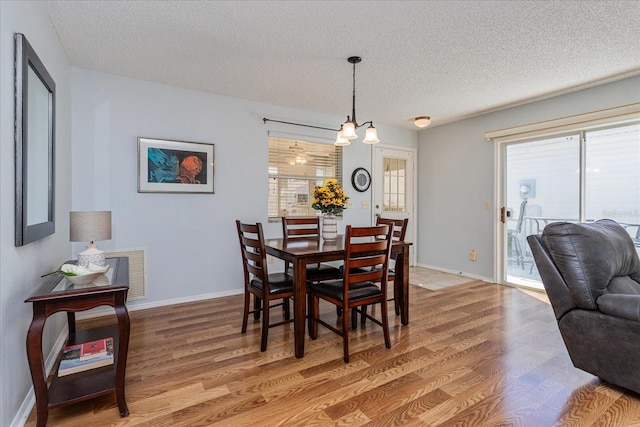 dining area with hardwood / wood-style floors and a textured ceiling