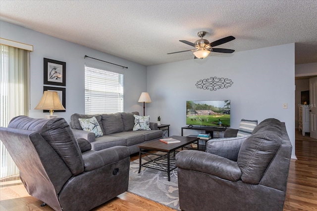 living room with a textured ceiling, hardwood / wood-style floors, washing machine and clothes dryer, and ceiling fan