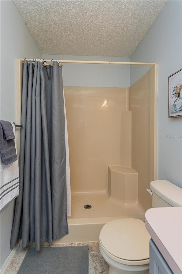 bathroom featuring toilet, vanity, a shower with curtain, and a textured ceiling