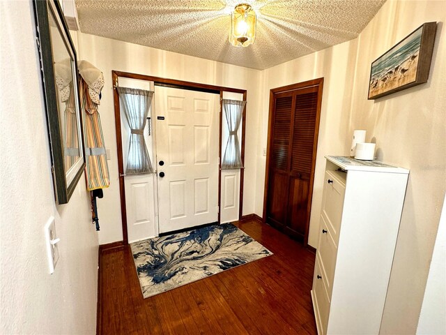 foyer with dark hardwood / wood-style flooring and a textured ceiling