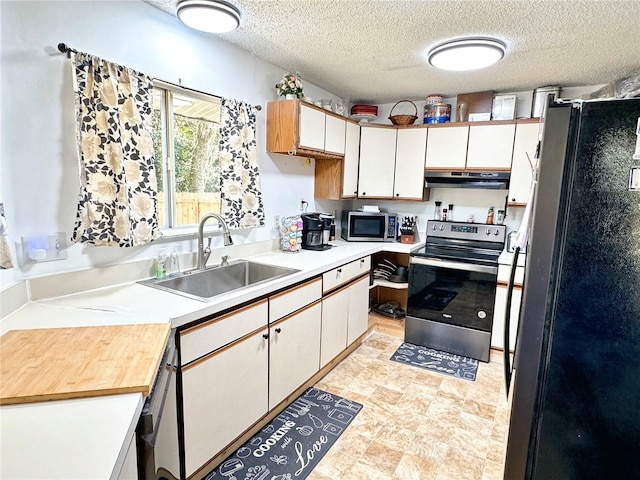 kitchen with white cabinets, sink, stainless steel appliances, and a textured ceiling