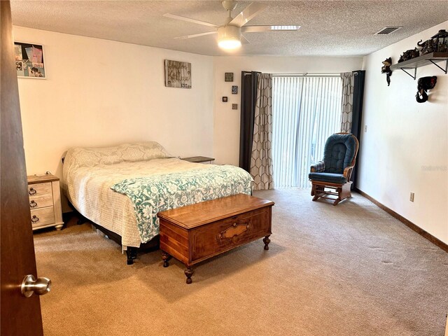 carpeted bedroom featuring ceiling fan and a textured ceiling