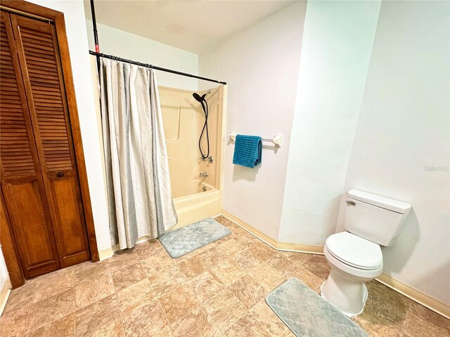 bathroom with shower / bath combo and toilet