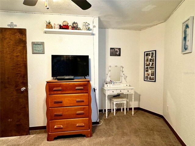 carpeted bedroom featuring ceiling fan and a textured ceiling