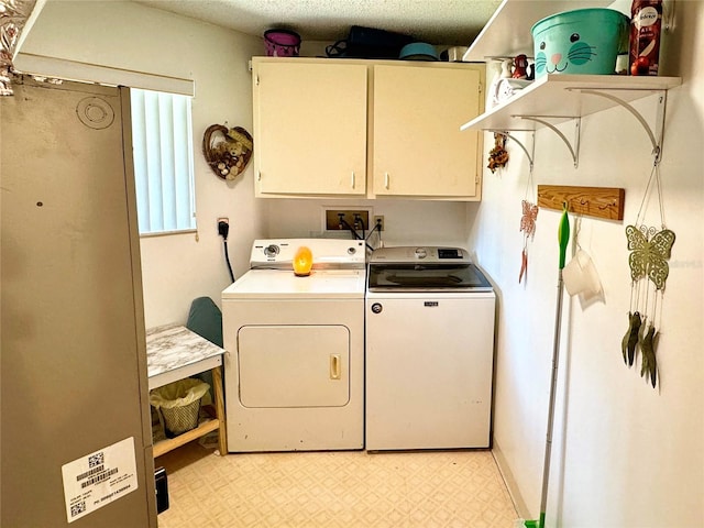 washroom with washer and dryer, cabinets, and a textured ceiling