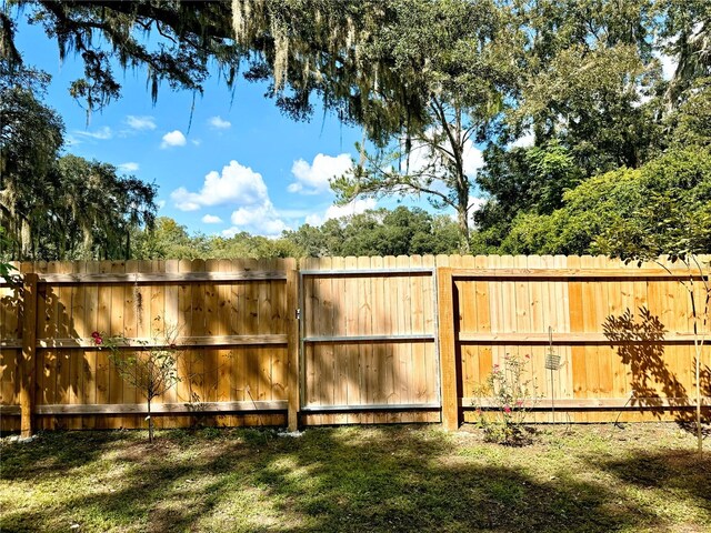 view of gate with a lawn