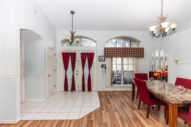 107 Needlewood Loop, Debary, FL 32713 - foyer entrance featuring a chandelier, arched walkways, light wood-style floors, and baseboards