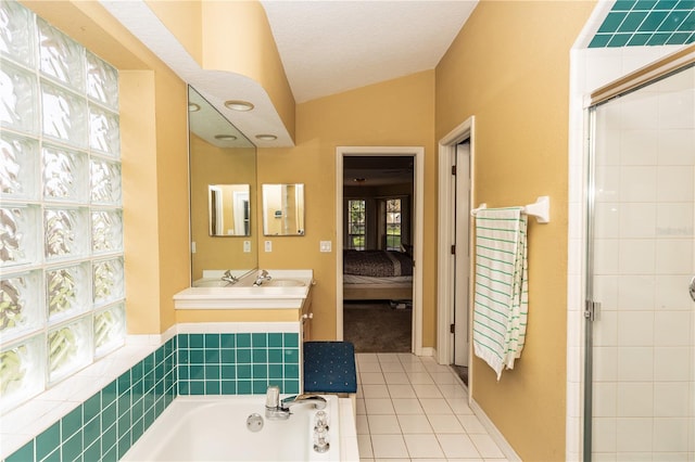 bathroom with vanity, lofted ceiling, independent shower and bath, a textured ceiling, and tile patterned flooring