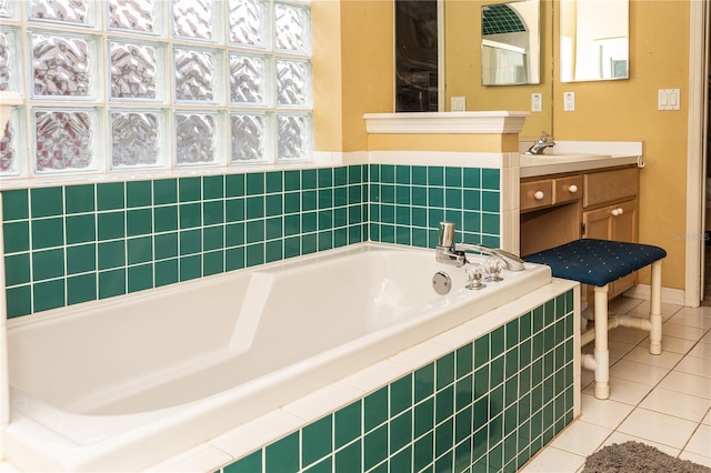 bathroom featuring vanity, tile patterned flooring, tiled tub, and a healthy amount of sunlight