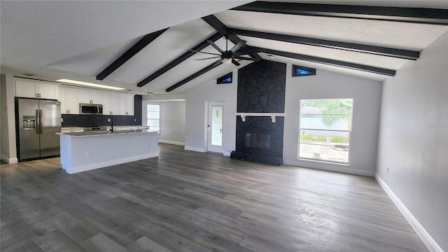 kitchen with a large fireplace, white cabinetry, dark hardwood / wood-style flooring, appliances with stainless steel finishes, and ceiling fan