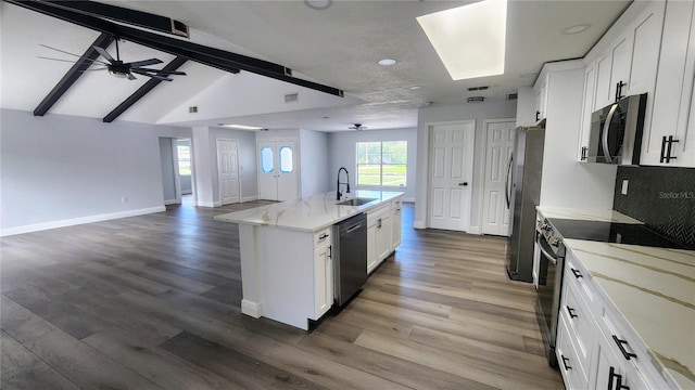 kitchen featuring hardwood / wood-style floors, white cabinets, stainless steel appliances, and sink