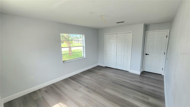 unfurnished bedroom featuring a closet and hardwood / wood-style floors