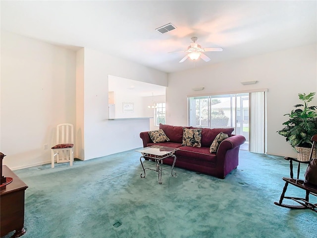 living room with ceiling fan with notable chandelier and carpet flooring