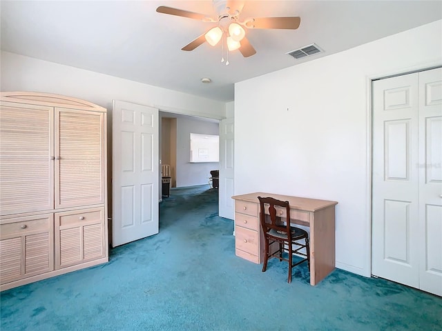 unfurnished office with ceiling fan and dark colored carpet