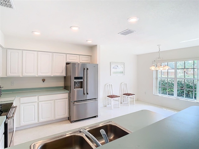 kitchen featuring pendant lighting, white cabinetry, a chandelier, and stainless steel appliances