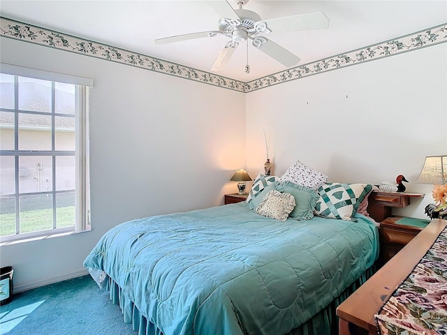 bedroom with multiple windows, ceiling fan, and carpet