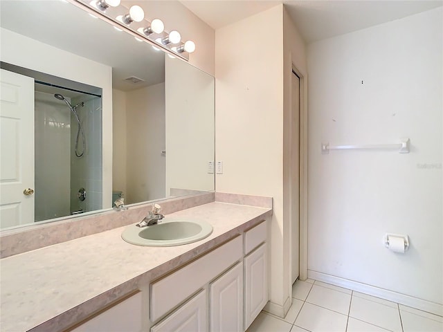 bathroom featuring a tile shower, tile patterned floors, and vanity