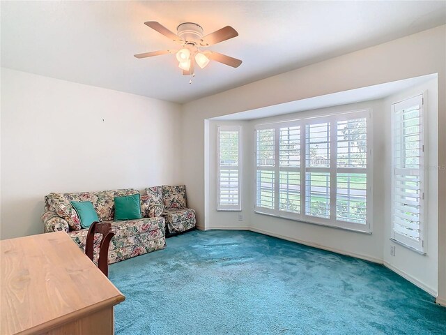 sitting room featuring ceiling fan, a wealth of natural light, and carpet flooring