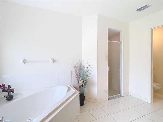 bathroom featuring shower with separate bathtub, tile patterned flooring, and toilet