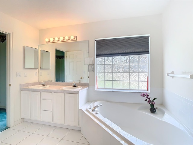 bathroom featuring tile patterned floors, vanity, and tiled bath