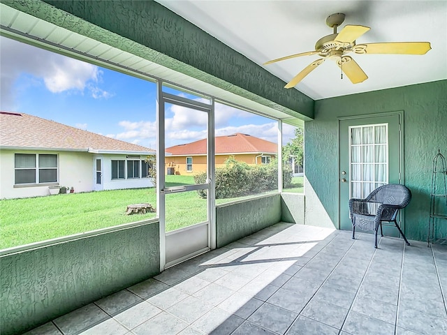 unfurnished sunroom featuring ceiling fan