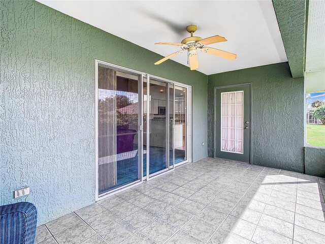 unfurnished sunroom featuring ceiling fan