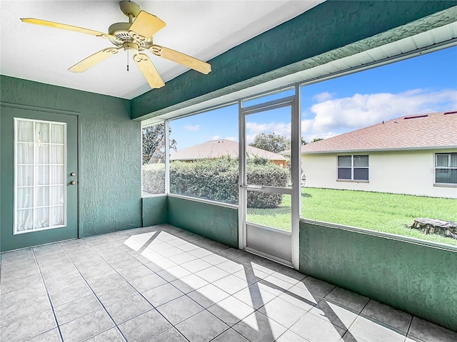 unfurnished sunroom with ceiling fan