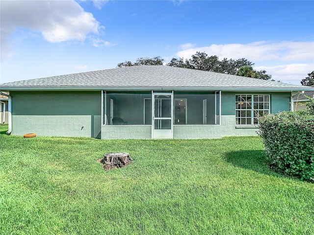 rear view of property featuring a sunroom and a yard