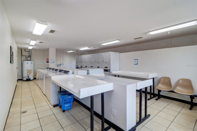 kitchen with a large island, stacked washer and dryer, water heater, and a kitchen breakfast bar