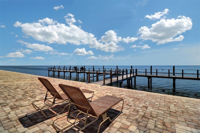 view of dock with a patio area and a water view