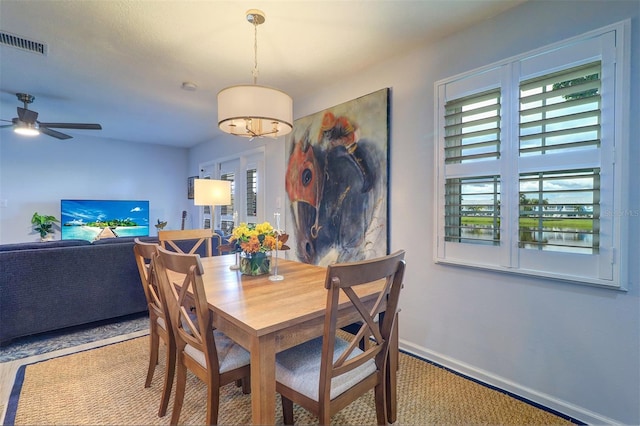 carpeted dining space with ceiling fan