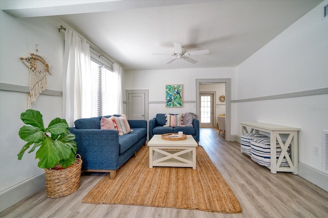 living room with light hardwood / wood-style floors, ceiling fan, and plenty of natural light